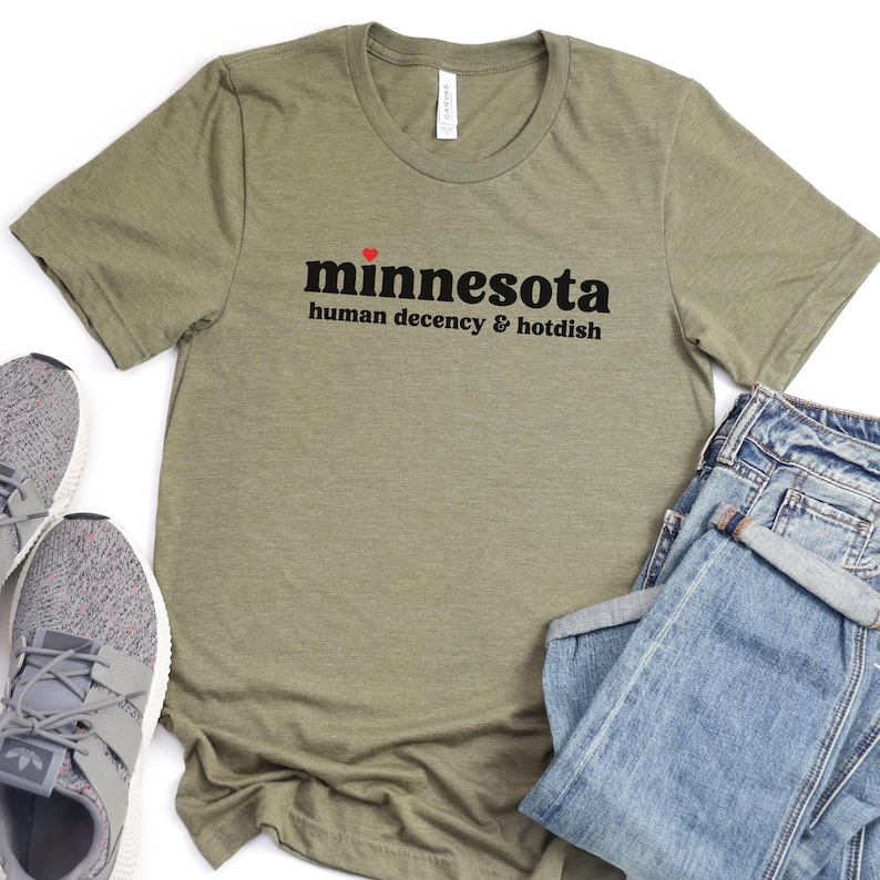 May include: A green t-shirt with the text "minnesota human decency & hotdish" in black with a red heart above the word "minnesota".