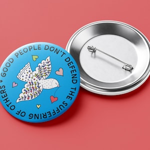 May include: A round, light blue button with the text "GOOD PEOPLE DON'T DEFEND THE SUFFERING OF OTHERS" encircling a white dove illustration. The dove has colorful wing details and is surrounded by hearts. A second, silver button is next to it.
