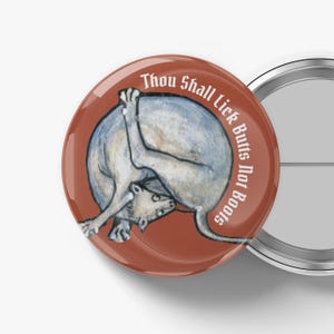 May include: A round, red button with the text "Thou Shall Lick Butts Not Boots" in white. The button features a watercolor illustration of a light blue animal licking its own rear end.