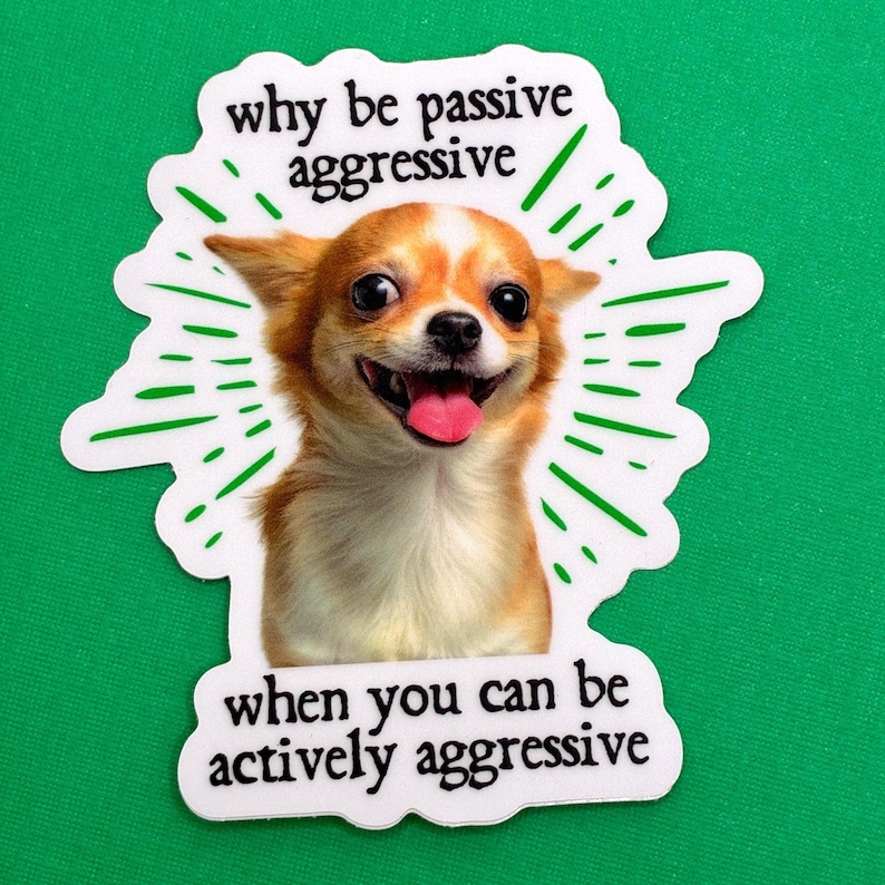 Pu&ograve; includere: Un adesivo bianco con un cane Chihuahua sorridente e il testo "why be passive aggressive when you can be actively aggressive" in nero. Il cane &egrave; marrone e bianco con la lingua di fuori, e linee verdi irradiano da dietro.