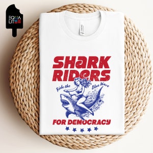 Shark Riders for Democracy Bella Canvas Camiseta unisex / Ride the Blue Wave, Girl Riding Shark Design, Camiseta de tiburón, Camiseta tormentosa, Regalo de tiburón