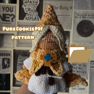 May include: Crocheted amigurumi doll of a character with a white beard and yellow and brown clothing. The doll is holding a brown folder with a white label that says "PURE COOKIE PDF PATTERN".