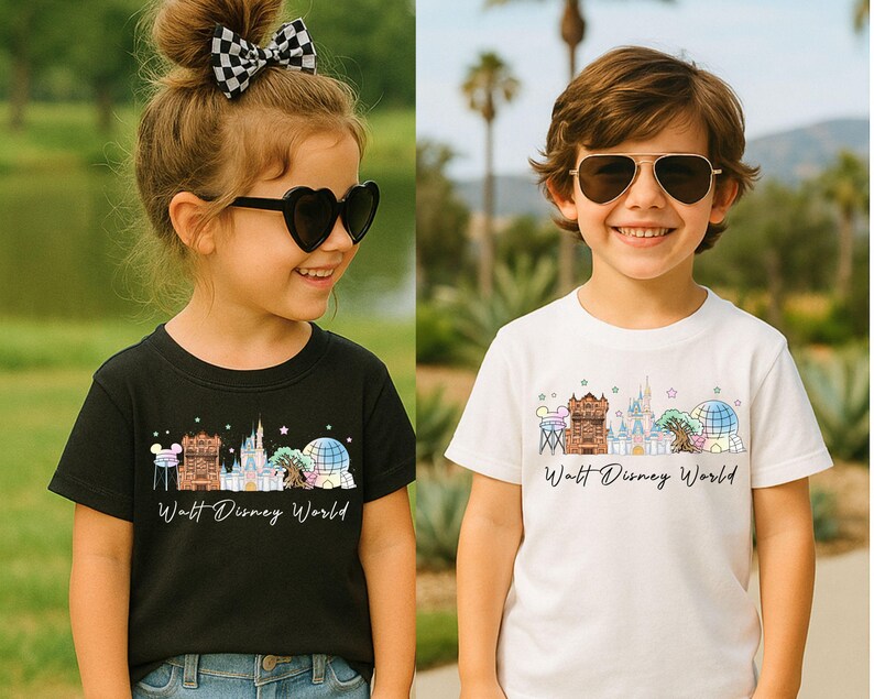 May include: A black t-shirt and a white t-shirt, each featuring a colorful graphic illustration of Walt Disney World landmarks including the castle, the tree, and the sphere, with the text Walt Disney World printed in a black cursive script.