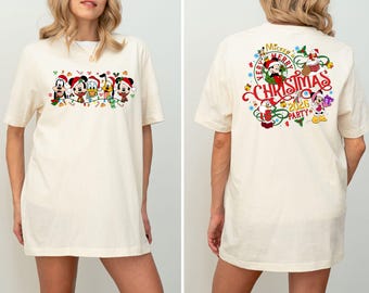 Peut inclure: T-shirt crème avec un motif festif. Le devant présente Mickey Mouse, Minnie Mouse, Donald Duck, Dingo et Pluto en tenues de Noël. Le dos du t-shirt porte l'inscription "Very Merry Christmas 2026 Party" avec Mickey et Minnie Mouse.