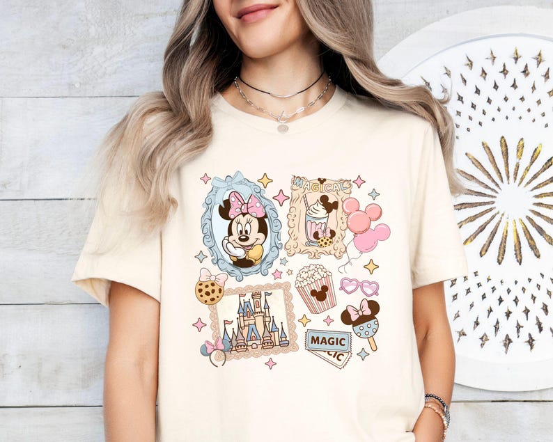Pu&ograve; includere: T-shirt color crema con un collage a tema Disney. Il design include Minnie Mouse, un castello, popcorn, gelato e palloncini. &Egrave; presente anche la parola "MAGICAL". La maglietta ha un classico girocollo.