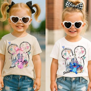 May include: Two young children wearing heart-shaped sunglasses and t-shirts. One shirt is tan with a pink bow and the word "Angel" and the other is white with the word "Stitch". Both shirts feature a cartoon design.