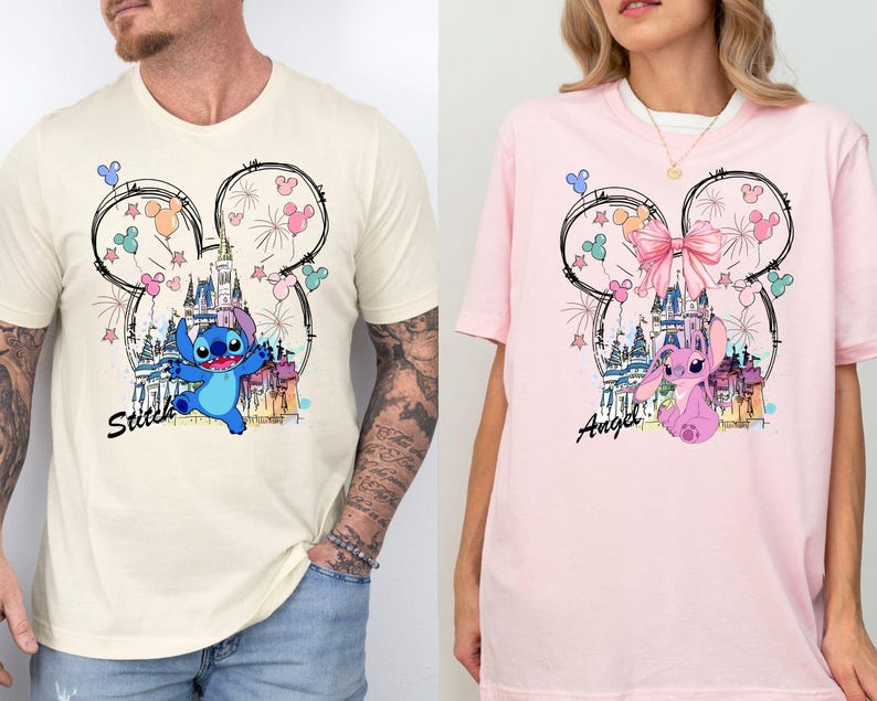 May include: Two t-shirts, one cream and one pink, featuring a cartoon design. The design includes a castle, fireworks, and a character named Stitch on the cream shirt and Angel on the pink shirt, all within a Mickey Mouse outline.