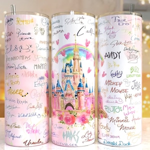 Könnte beinhalten: Drei Edelstahlbecher mit rosa-weißem Farbverlauf. Jeder Becher zeigt Unterschriften von Disney-Charakteren und ein Aquarellschloss-Design mit einem Regenbogen.