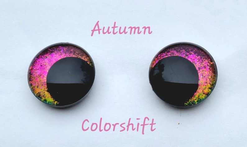 May include: Pair of black and iridescent glass eyes with a pink and gold color shift. The eyes are labeled "Autumn Colorshift".
