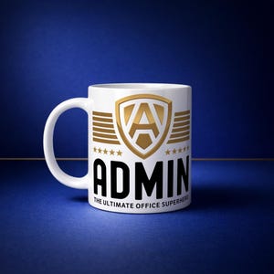 May include: White ceramic mug with a gold and black design. The mug features the word "ADMIN" in bold black letters, with a gold shield and star graphic. The text "THE ULTIMATE OFFICE SUPERHERO" is below the word "ADMIN".