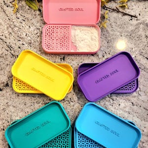 May include: Five colorful, rectangular containers with lids. Each container has a white label with the text "Crafted Soul". The containers are pink, yellow, purple, teal, and blue.