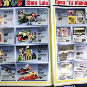 May include: A Toys 'R' Us advertisement page featuring various toys and electronics. The page includes action figures, video games, and educational toys. The text "Shop Late Open 'Til Midnight!" is visible at the top of the page.