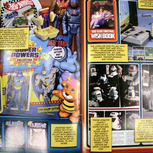 May include: A vintage advertisement spread from the 1986 Sears Christmas Wish Book. The pages showcase toys, including Hot Wheels cars, E.T. lunchboxes, Batman figures, and a Nintendo Entertainment System. The catalog also features robots and other collectibles.