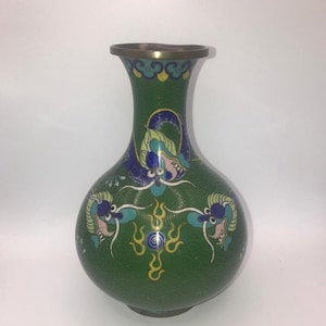 Könnte beinhalten: Grüne dekorative Vase mit bauchigem Körper und schmalem Hals. Die Vase zeigt ein detailliertes Design von Drachen und floralen Mustern in Blau, Rosa und Gelb. Der Rand ist bronzefarben.