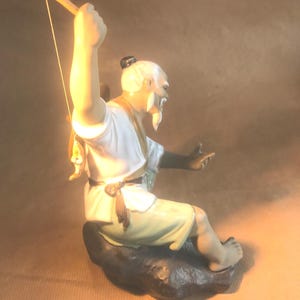 Un tesoro senza tempo: la serenità di una statuetta di un pescatore di fango Shiwan