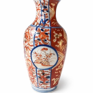 Può includere: Un vaso in ceramica con base bianca e dettagliati motivi dipinti a mano in vivaci tonalità di arancione, rosso e blu cobalto. Il design include motivi floreali, pannelli geometrici e un medaglione circolare centrale con piante.