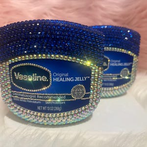 May include: Two jars of Vaseline Original Healing Jelly, decorated with blue and iridescent rhinestones. The jars have a blue label with white text, including "Original Healing Jelly" and "Dermatologist Recommended". Each jar contains 368g of product.