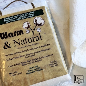 May include: A package of Warm & Natural needled cotton batting for quilting, crafts, and wearable arts. The package is tan with the product name and cotton plant illustrations. The batting measures 45 inches by 60 inches.