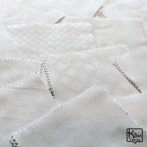 Precut bundle 5 inch charm pack fabric stacker includes 42 pieces. Cotton fabric charm pack from Maywood Studio. This cute white on white charm pack has hearts, stars, swirls, flowers and so much more. Great fabric bundle for quilters and crafters.