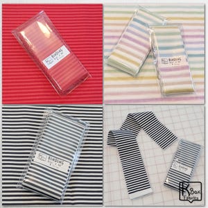May include: Four images showcasing fabric binding strips in various colors and patterns. One image features red striped binding, another displays pastel stripes, and two show black and white striped binding. Each is packaged and labeled.