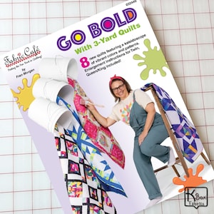 May include: A quilting pattern book titled GO BOLD With 3-Yard Quilts by Fabric Café. The cover features three white buckets pouring colorful patterned fabric, a person painting on a quilt, and text detailing 8 new quilt designs.