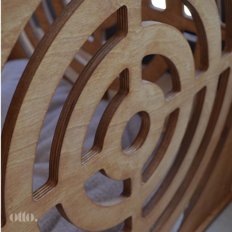 May include: A close-up of a wooden toy with a circular design. The toy is made of light brown wood and has a series of concentric circles cut into the surface. The circles are arranged in a spiral pattern, creating a visually interesting design. The toy is made of plywood and has a natural wood finish.