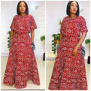 May include: A red and white patterned two-piece dress with a short-sleeved crop top and a long skirt. The dress has a geometric pattern with white lines and circles on a red background.