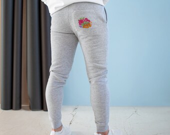 May include: Gray sweatpants with a colorful graphic print on the back pocket. The graphic features a variety of fruits and vegetables.