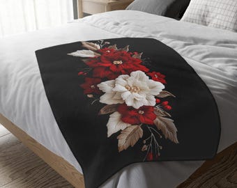 Könnte beinhalten: Eine schwarze Kuscheldecke mit einem Blumendesign aus roten und weißen Blumen mit braunen Blättern. Die Blumen sind in einem vertikalen Strauß angeordnet.