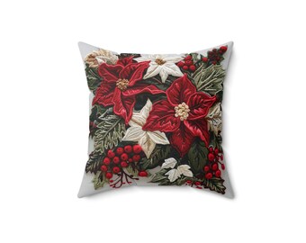 May include: Square throw pillow featuring a festive poinsettia design. The pillow showcases vibrant red and white poinsettia flowers, green leaves, and red berries. The design is embroidered on a white background, creating a textured, seasonal accent.