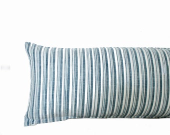 May include: A long, rectangular pillow with a blue and white striped pattern. The pillow is made of a soft, textured fabric.