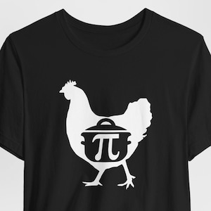 Puede incluir: Camiseta negra con una silueta blanca de una gallina llevando una olla con un símbolo de pastel dentro.