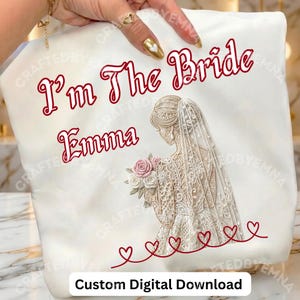 Peut inclure: Sac fourre-tout blanc avec l'inscription "I'm The Bride Emma" en rouge. Il présente une illustration d'une mariée avec un voile en dentelle tenant un bouquet de roses roses, avec des cœurs rouges en bas. "Custom Digital Download" est en bas.