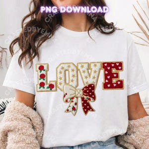 May include: White t-shirt with the word "LOVE" embroidered in gold, red, and white. The "L" features red roses, the "O" has gold stars, the "V" is a bow with red hearts and roses, and the "E" is red with gold trim.