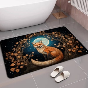 May include: A bathroom rug with a dark blue background featuring a fox sitting in a moonlit forest. The fox is orange and white with a bushy tail. The forest is made up of brown branches and golden leaves. The moon is a bright blue and white.