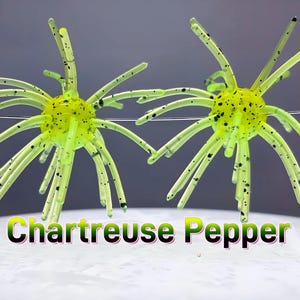 May include: Two chartreuse fishing lures with black speckles, each featuring a central spherical body with multiple radiating flexible tentacles. The text Chartreuse Pepper is displayed in a bold font at the bottom of the image.