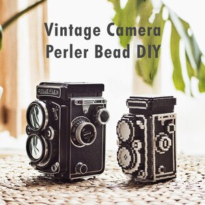 May include: Two vintage cameras, one a real Rolleiflex camera and the other a DIY version made with black and white Perler beads. The bead camera is a replica of the Rolleiflex.