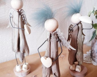 Adorable guardian angels made of driftwood with metal wings and wooden shoes