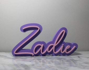 May include: Purple and pink 3D name sign that says "Zadie".