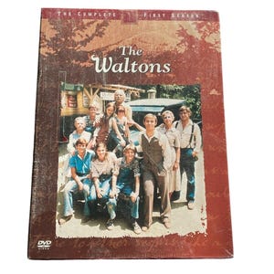 以下が含まれることがあります： ウォルトンの家族の完全版シーズン1のDVDボックスセット。ボックスは赤い背景に白い文字で番組のタイトルが書かれています。ボックスの前面には、ウォルトン家の家族が家の前で立っている写真が掲載されています。
