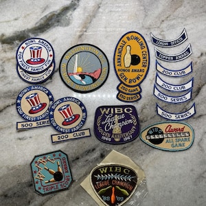 Pode incluir: Uma coleção de dez patches bordados com designs de boliche. Os patches são de várias cores, incluindo vermelho, branco, azul, amarelo, verde e preto. Alguns patches incluem texto, como "Bowl America", "League Champion" e "500 Series".