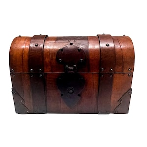 May include: A brown wooden chest with a domed lid, featuring dark brown leather-like straps and metal accents. The chest is secured with a heart-shaped metal latch and reinforced with metal corner plates, all fastened with small dark metal studs.