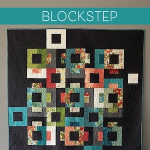 May include: A quilt pattern called "Blockstep" by Robin Pickens. The pattern is for a quilt with a geometric design in shades of teal, green, red, and white. The quilt is shown on a black chair with a white background.