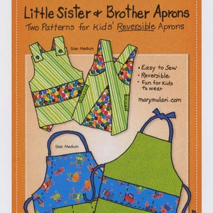 May include: An orange background with a blue banner that reads "Mary Mulari DESIGNS". The image shows patterns for reversible aprons for kids. The aprons are green, blue, and patterned with robots and colorful shapes. The text says "Little Sister & Brother Aprons".