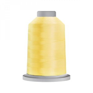 May include: A spool of pale yellow thread on a grey plastic bobbin.