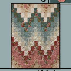 May include: A patchwork quilt with a floral design in shades of pink, teal, and cream. The quilt features a zig-zag pattern and is framed by a black border. The text "Elsie May" and "Villa Rosa Designs" are visible.