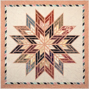 May include: A quilt with a large, multi-colored star design. The star is made up of many smaller, geometric shapes. The background of the quilt is a light cream color.