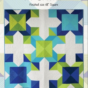 May include: A quilt pattern called "Ice Breaker" with a finished size of 68 inches square. The pattern features a geometric design with blue, green, and white squares and triangles. The pattern is by Joanna Marsh and is available on kustomkwilter.com. The Instagram handle for the designer is @kustomkwilts.