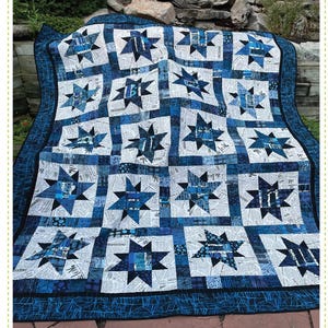 May include: A blue and white quilt with a star pattern. The quilt is called "Pinballs" and is an intermediate pieced quilt. The quilt is made by Quilting Renditions.