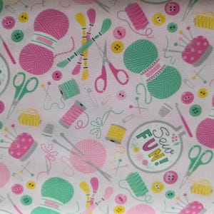 May include: A light pink fabric featuring a repeating pattern of sewing and knitting supplies including pink and green yarn balls, scissors, spools of thread, buttons, needles, and an embroidery hoop with the text Sew FUN!